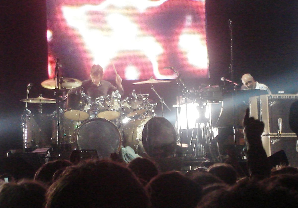 Zak Starkey mid-fill behind his Who drum kit in 2007, Pete Townshend at his amps to the right