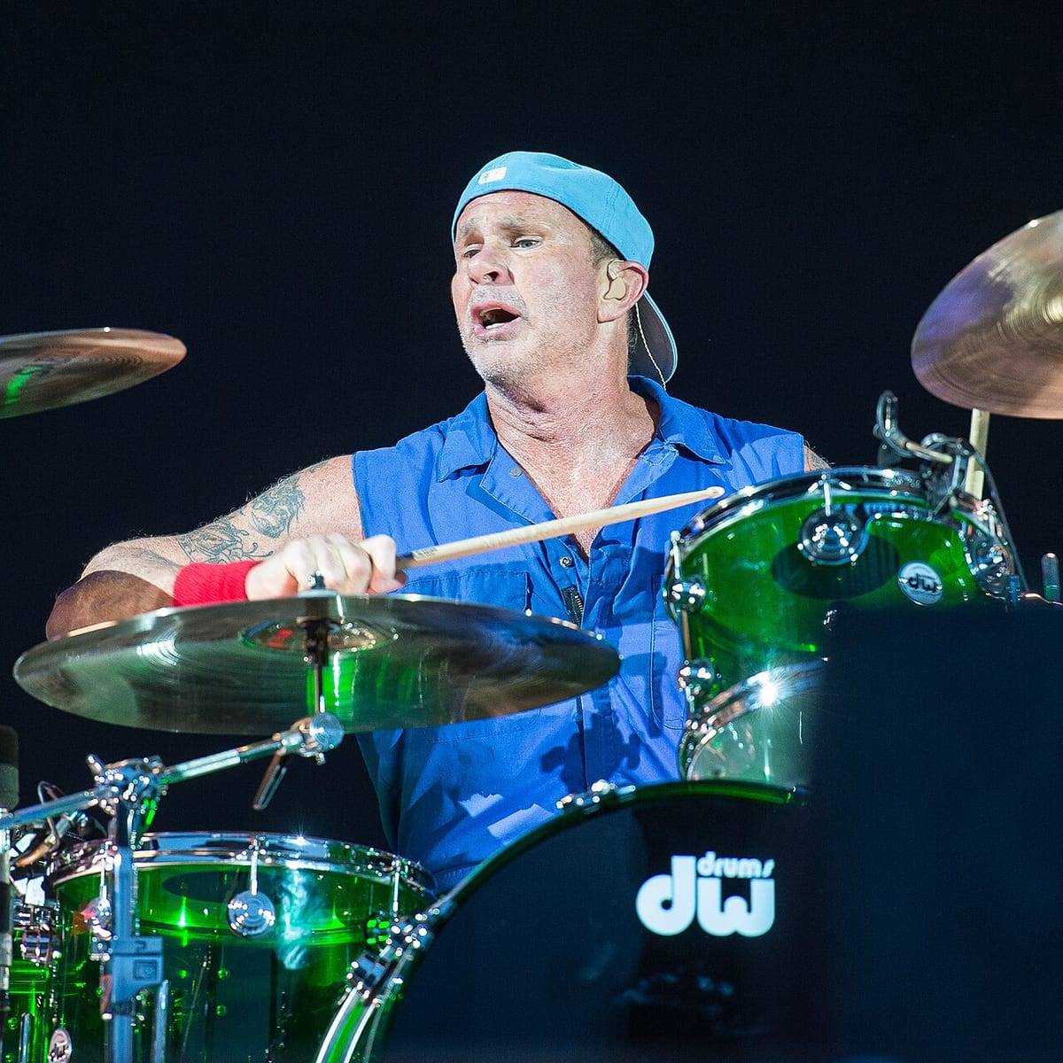 Chad Smith behind his DW kit in a backwards cap, mid-song, playing a green Collector's Series shell pack