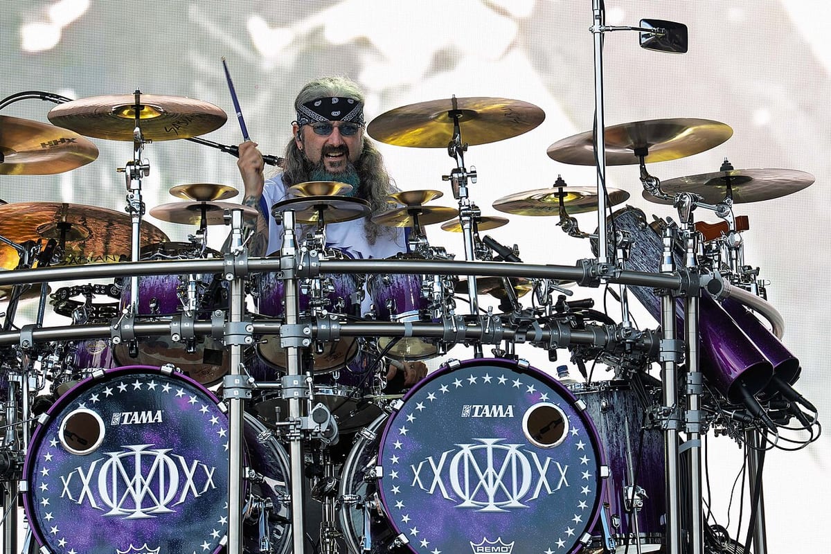Mike Portnoy behind his purple Tama Starclassic Monster kit, sticks raised, ringed by Sabian cymbals