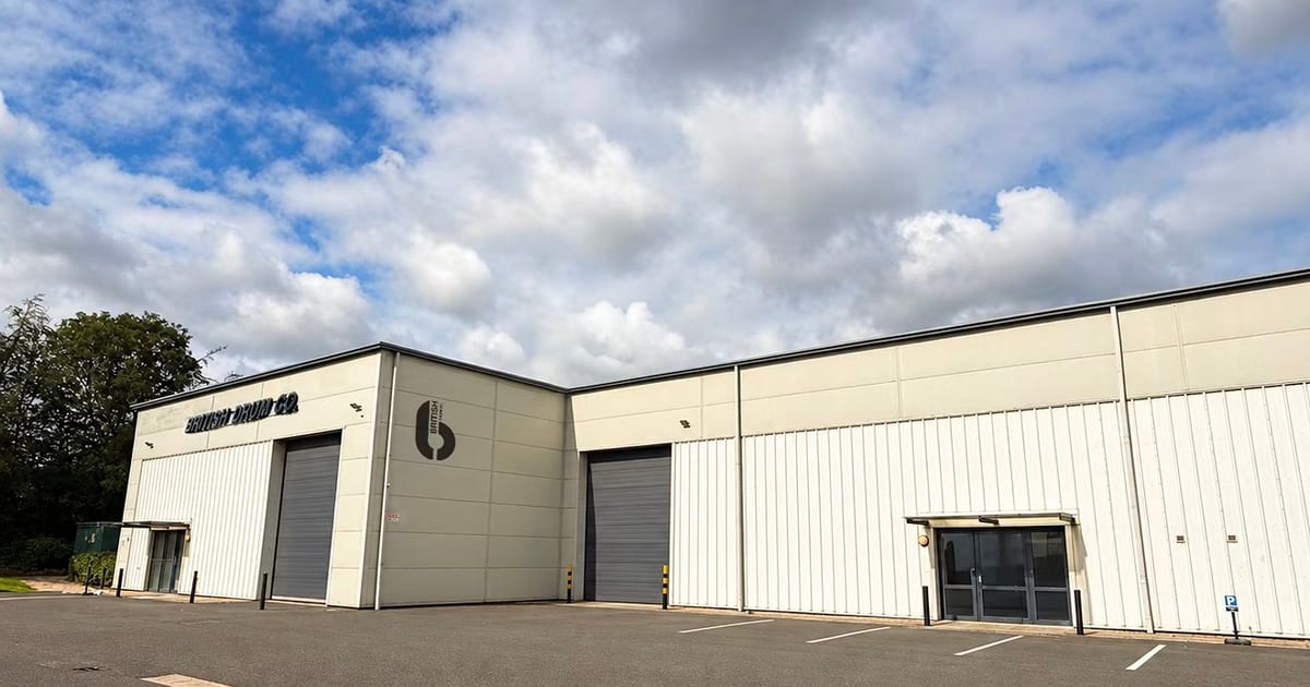 A British Drum Co. building with the company name and logo on its cladding and two roller shutter doors