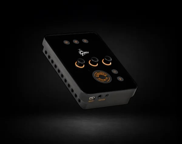 The black Gretsch Catalina EVO drum module with three orange-ringed knobs, a small display and trigger inputs along the side